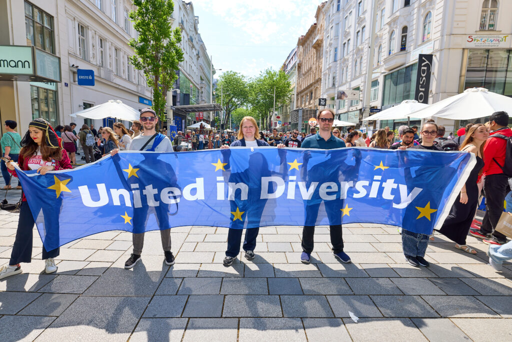 auf der Mariahilfer Straße halten 5 Personen ein Transparent mit der Aufschrift "United in Diversity"
