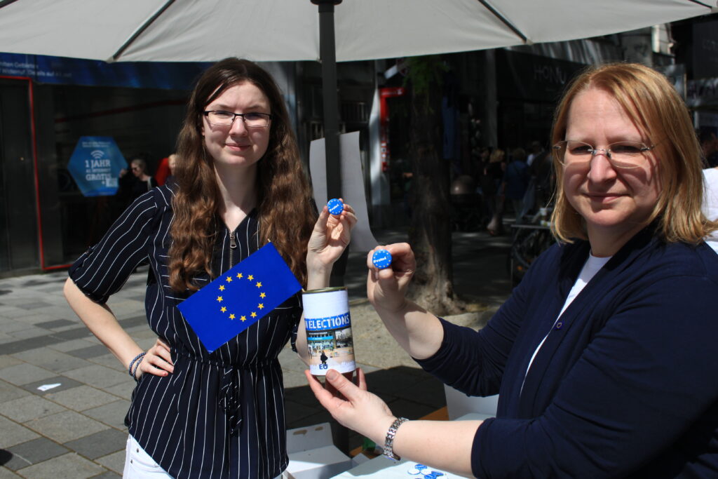 zwei Personen halten Buttons mit #vote4EU