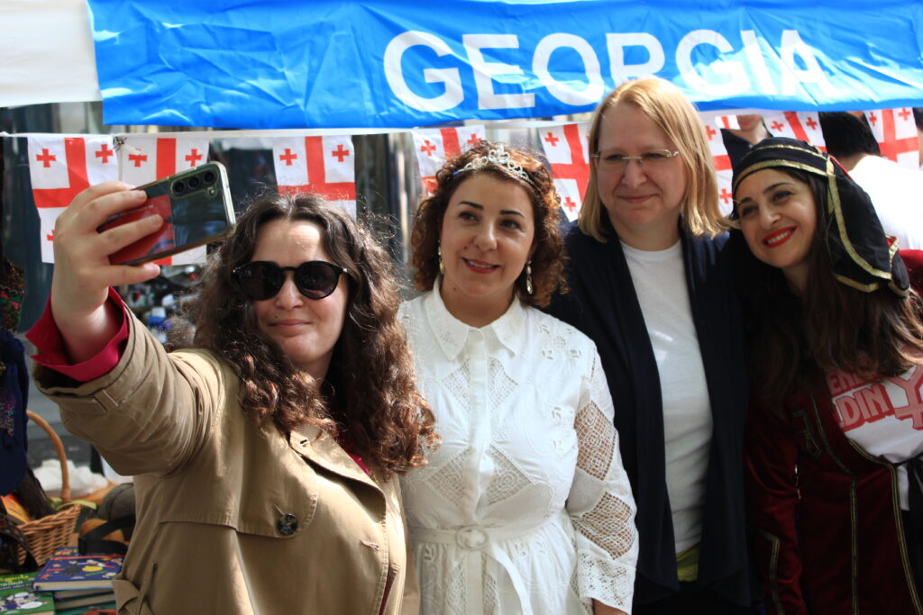 4 Personen machen ein Selfie vor dem Stand von Georgien